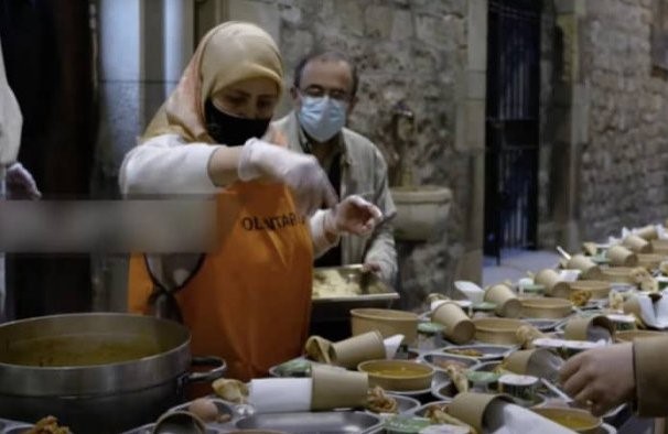 Voluntaria musulmana sirviendo el iftar en el claustro de la iglesia santa ana